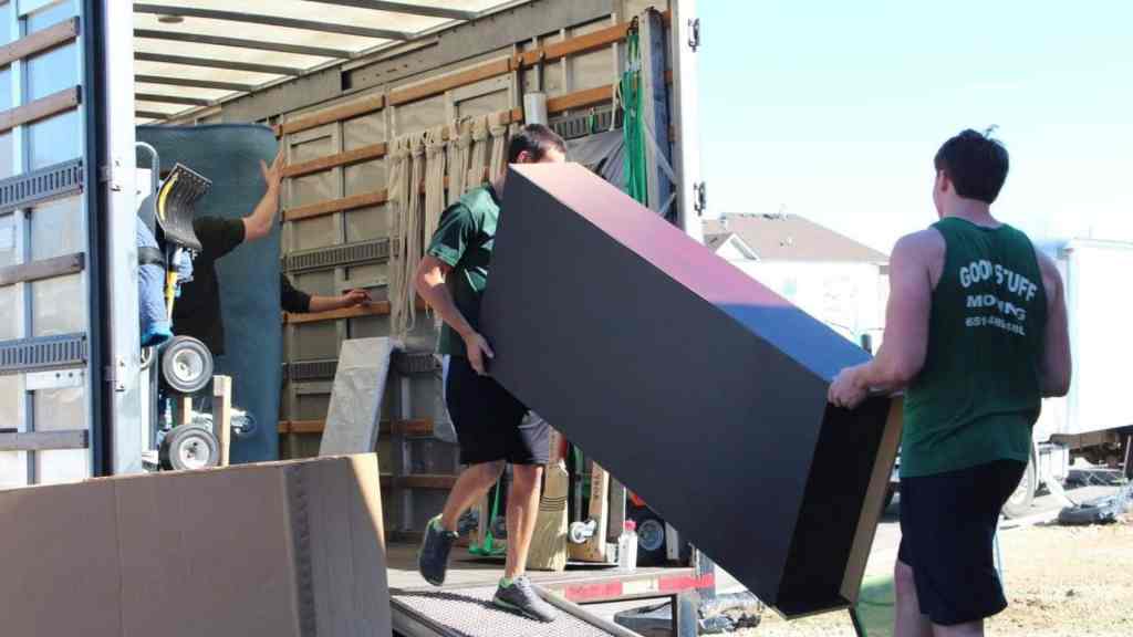good stuff team members loading a large piece of furniture into a moving truck