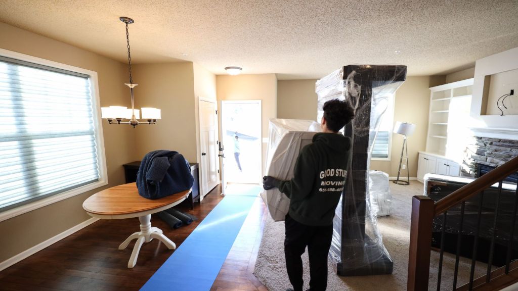 Team members lifting furniture out of a house