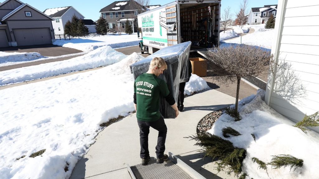Team members carrying furniture into moving truck