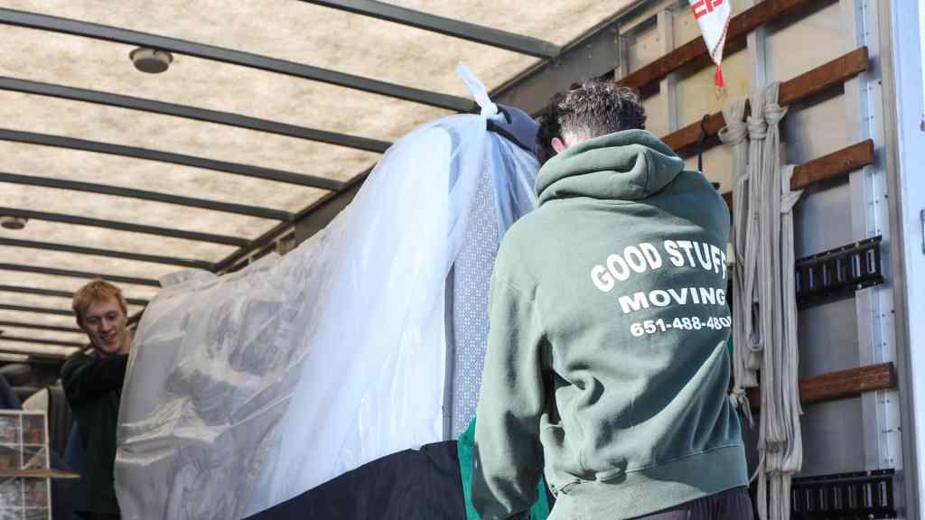 Two good stuff team members lifting a mattress into a moving truck