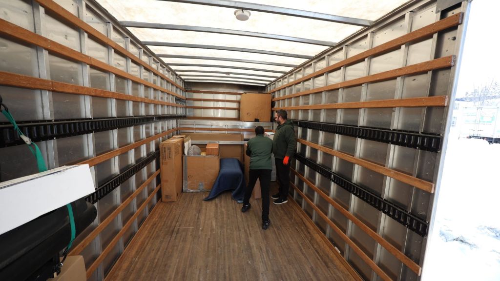 Two good stuff movers inside an empty moving truck