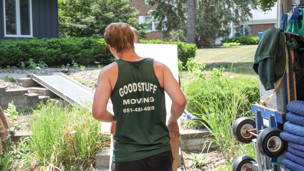 two good stuff moving team members unloading a piece of furniture