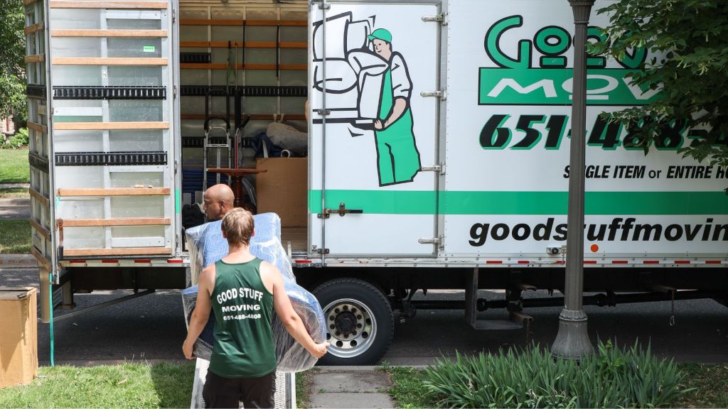 two good stuff movers carrying a heavy piece of furniture