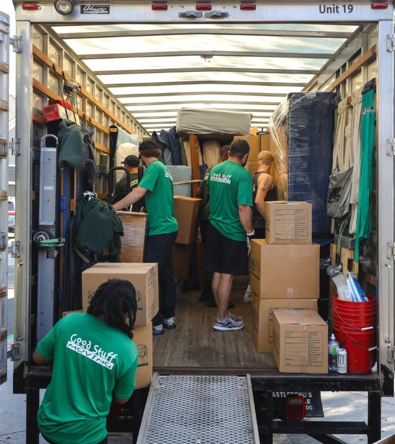 a group of good stuff movers unloading boxes from the back of a moving truck