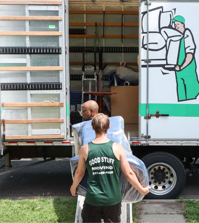 Good Stuff Moving full-service movers carrying a wrapped couch into a moving truck for a Minneapolis home move
