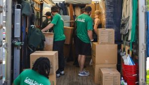 Home 34 Six Good Stuff movers unloading boxes from the back of a moving truck