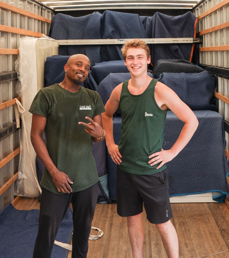 Two Good Stuff movers standing side by side in the back of a moving truck