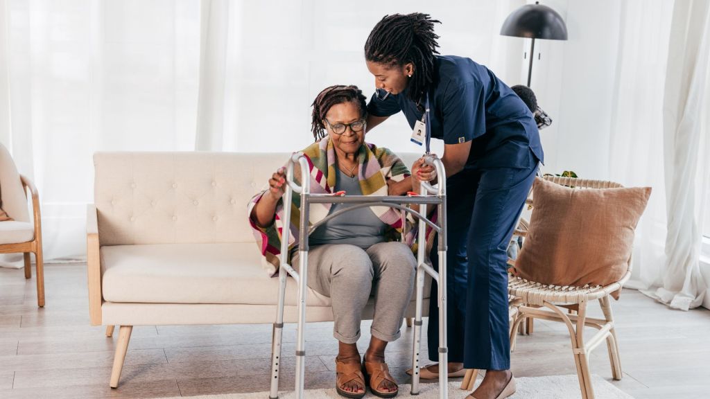 Caregiver helping a senior woman with a walker during a move