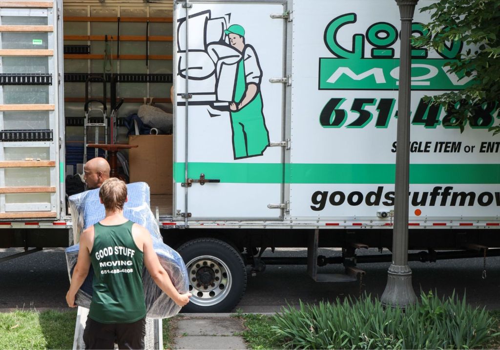 Two Good Stuff movers loading furniture into a moving truck