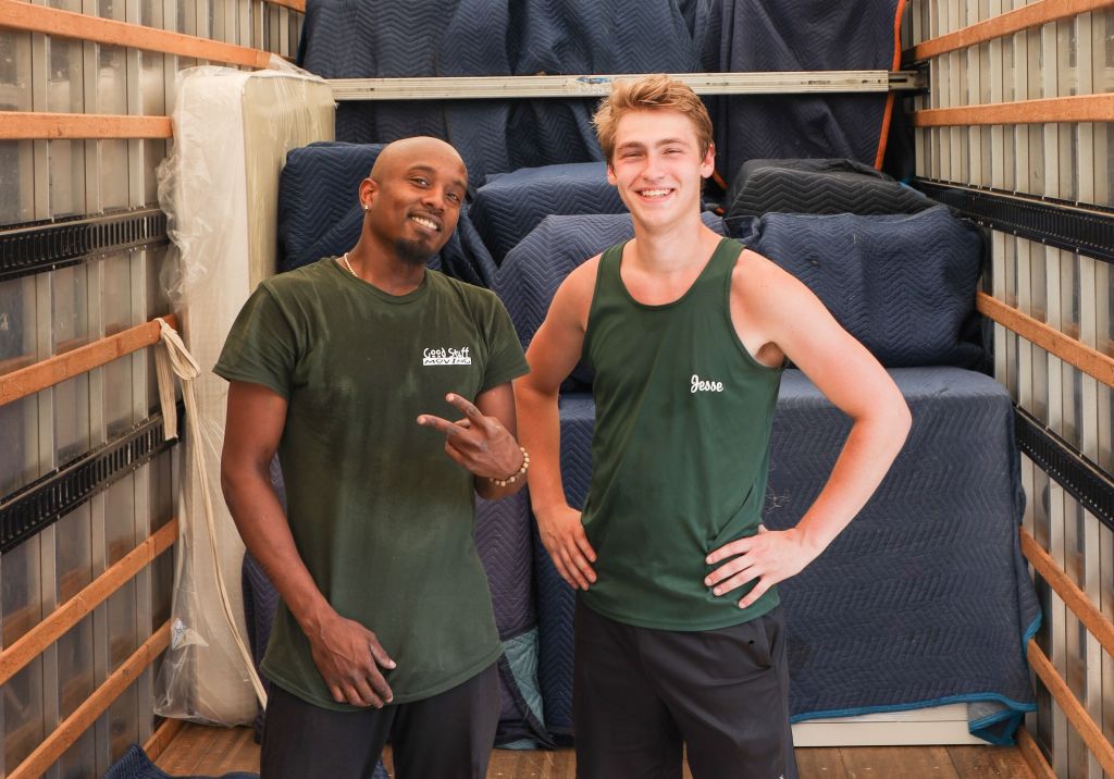 Two Good Stuff movers standing side by side in the back of a truck