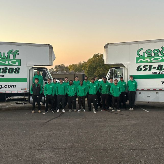 the good stuff moving team in front of two moving trucks